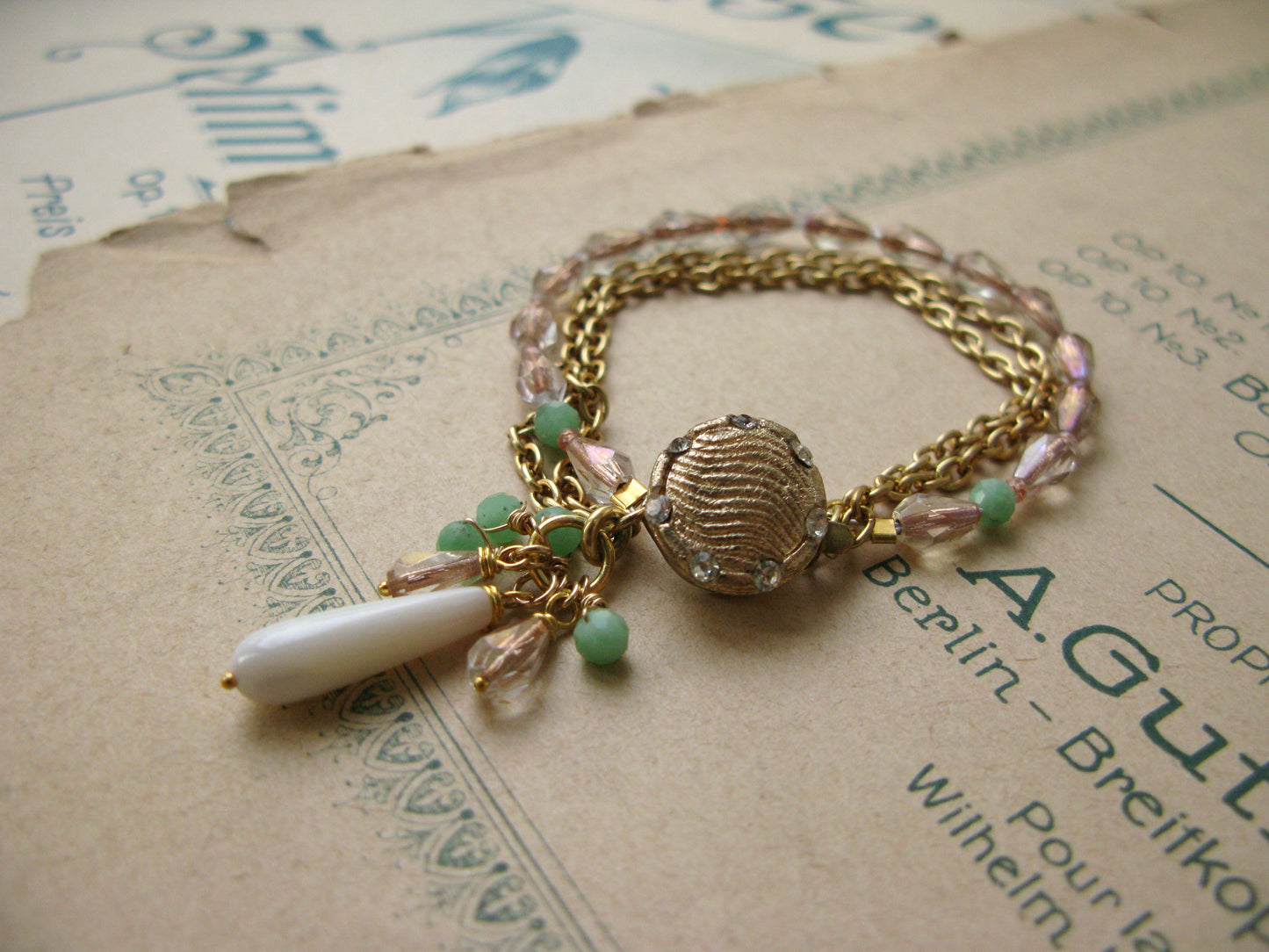 Gold tone bracelet with chains, glass and gemstone beads.