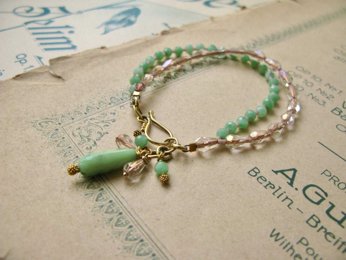 Green and gold tone beaded bracelet with glass and gemstones.