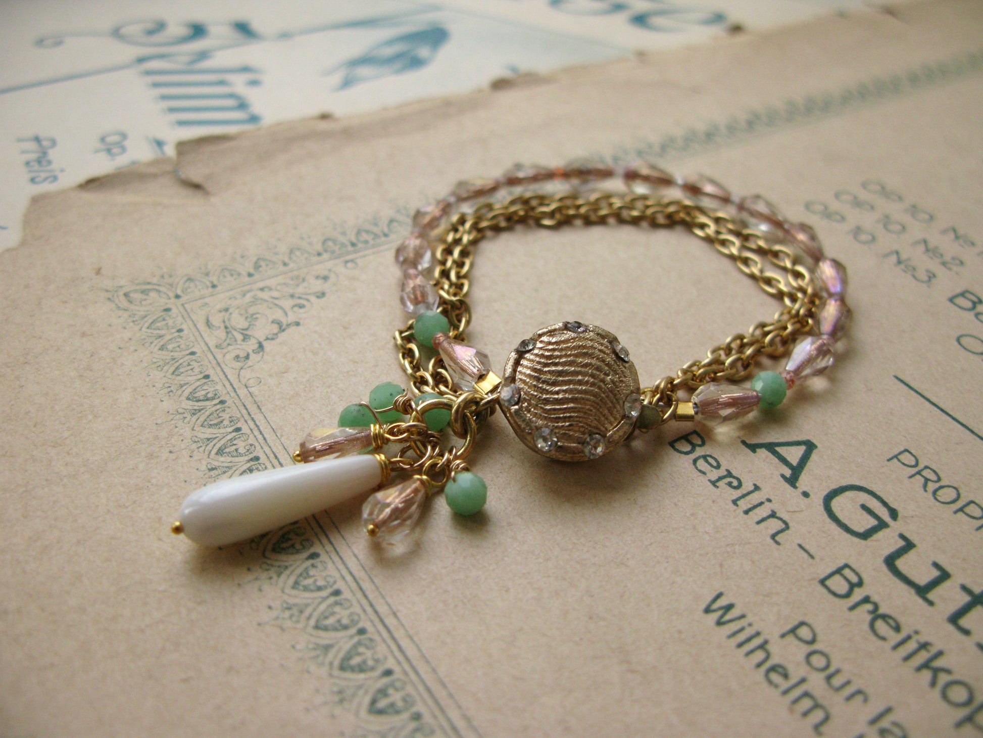 Gold tone bracelet with chains, glass and gemstone beads.